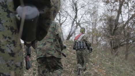 jugadores de paintball en camuflaje en un bosque