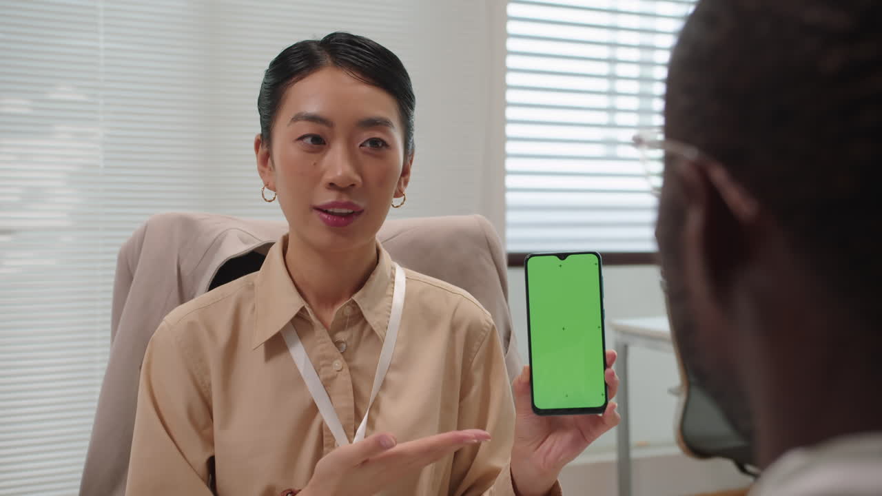 Female Consultant Showing Banking App on Smartphone to Client