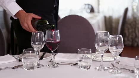 waiter pouring a bottle of red wine
