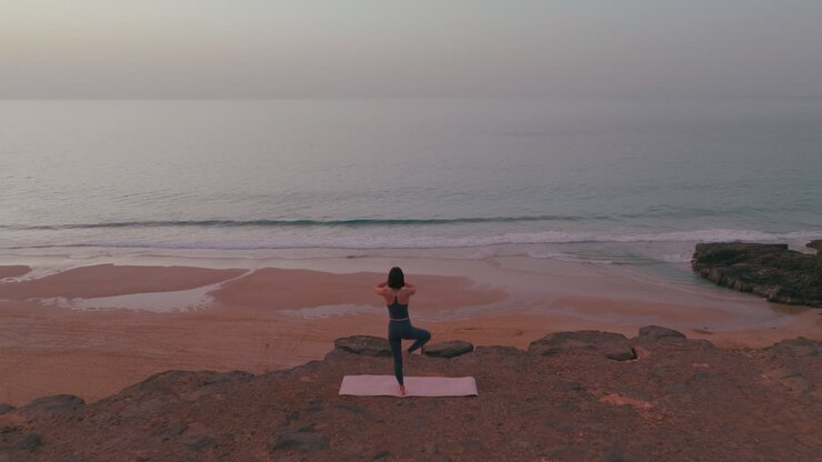 Woman Practicing Yoga on a Beach Cliff at Sunrise/Sunset