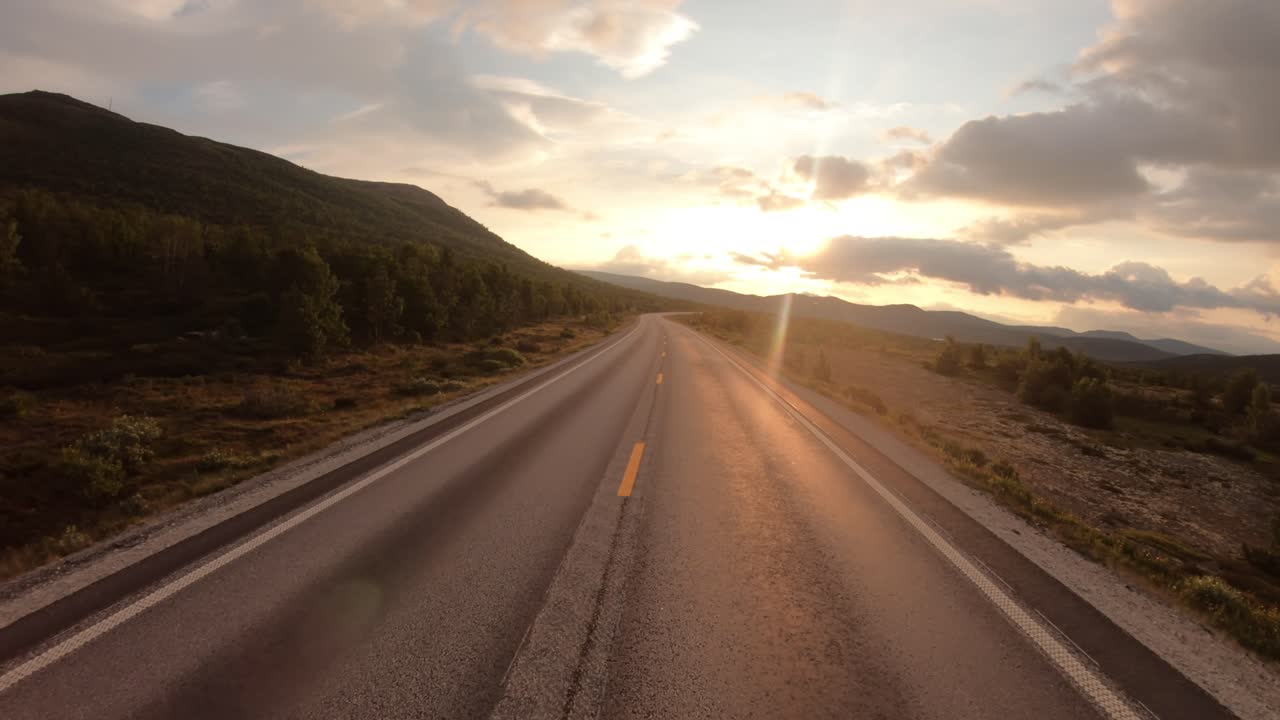 Conduciendo un coche por una carretera en Noruega al amanecer