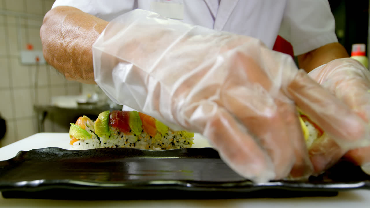 chef masculino arreglando sushi en una bandeja en la cocina 4k