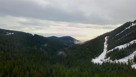 shot from above of snowy mountains in vancouver, canada just after sunrise