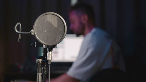 el director de audio opera en un estudio de música. un hombre profesional afina la pista usando una mesa de mezcla con una computadora. proceso de producción de arte musical