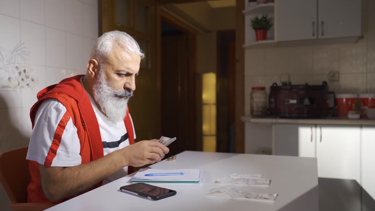Hombre maduro trabajador calculando las facturas de fin de mes e intentando pagarlas