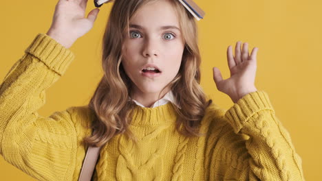 happy teenage caucasian girl student holding notebook on her head.