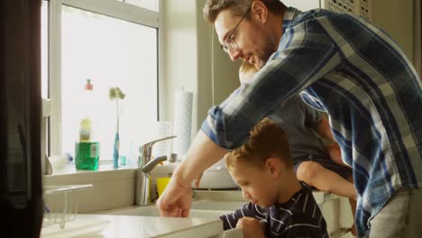 father and siblings cleaning kitchen sink 4k