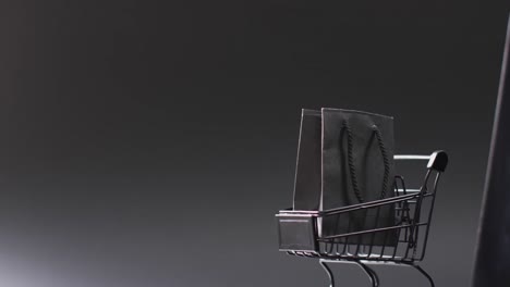 video de portátil con pantalla en blanco, bolsa de compras y carrito con espacio de copia sobre fondo blanco