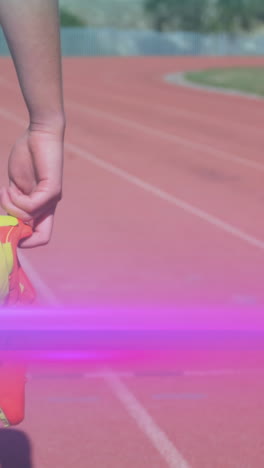 animation of light moving over midsection of woman holding running shoes walking on running track