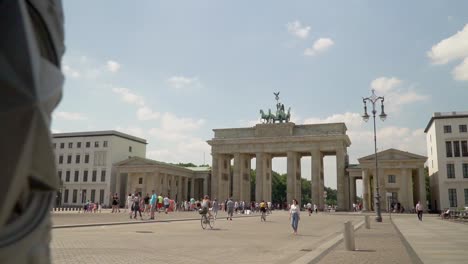 tourists at brandenburg gate famous monument in berlin, germany - panning reveal