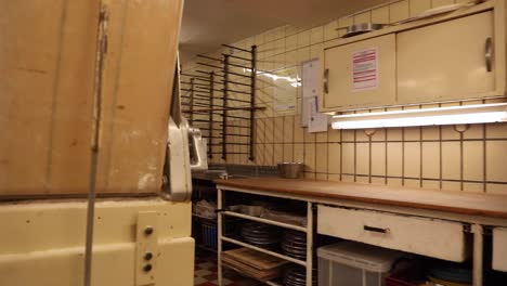walking inside the kitchen of an empty bakery with baking tools and equipment - handheld shot