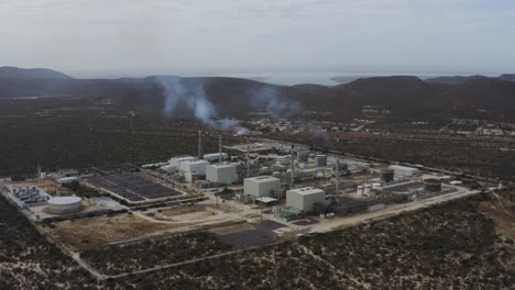 vista aérea de una central eléctrica de gas con humo saliendo de las chimeneas