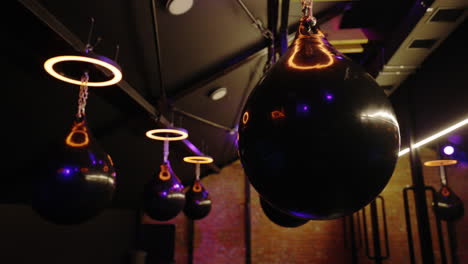 dark boxing gym with hanging punching bags