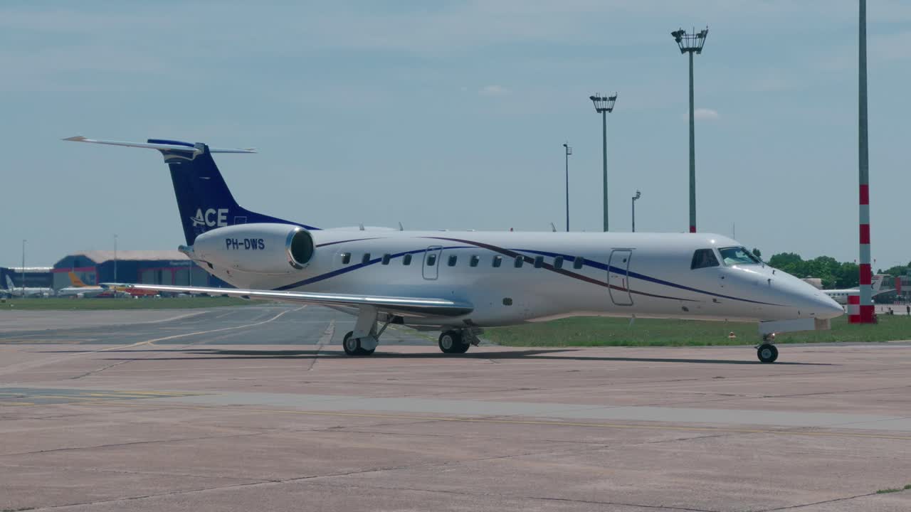 A Jet Airplane Taxis to the Parking Stand at an Airport - Sunny Day