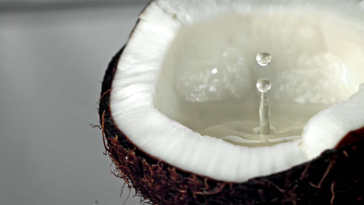 Slow Motion Water Drop Splashing into Fresh Coconut Water