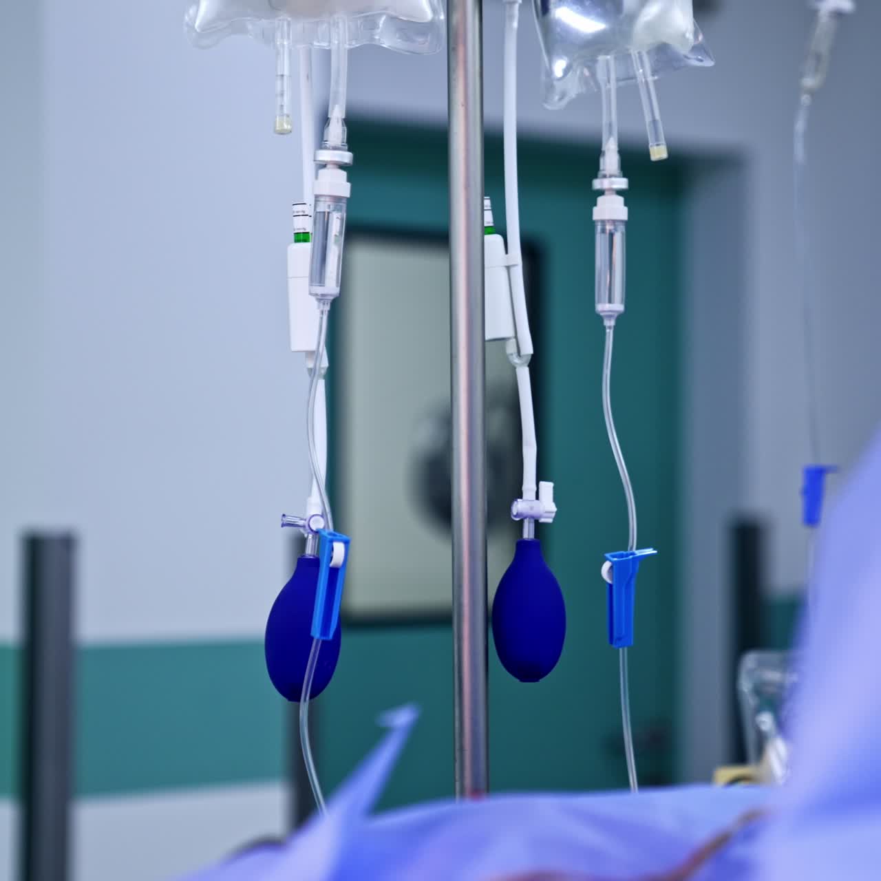 Drop counter stand with two sets of plastic bags with medicines. Blue pear pumps hang from the droppers