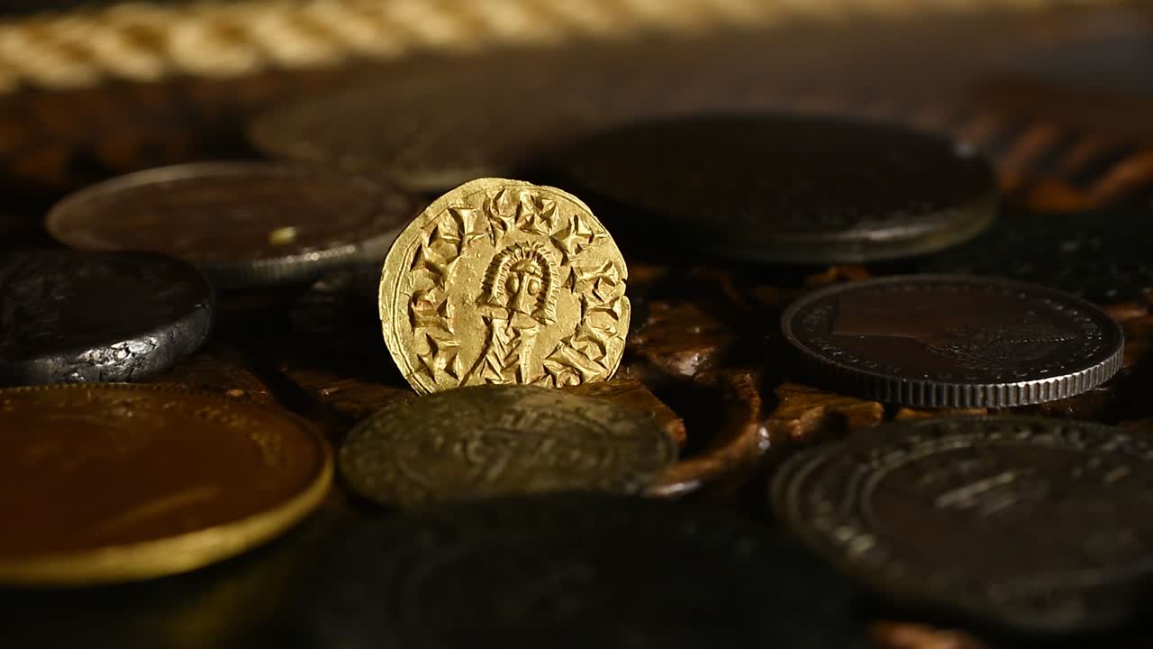 Vecchia moneta d'oro visigota in un vecchio scrigno di legno rotante.