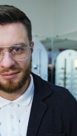 man trying on glasses in optical store