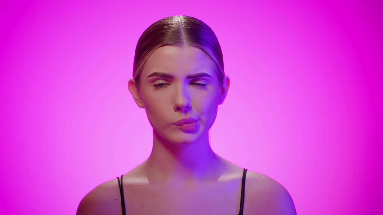 mujer linda hace caras tontas con la boca y los ojos rodando, pensando en