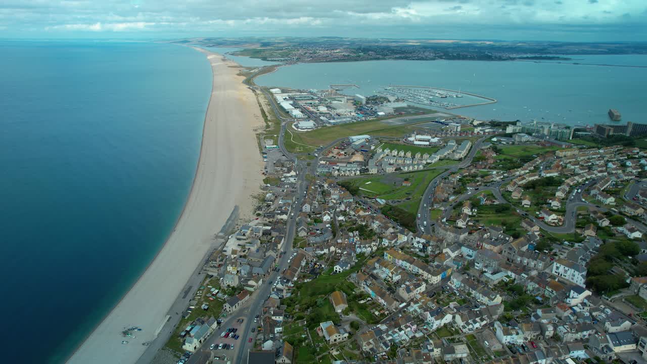 Chesil Beach med utsikt mot Weymouth från Isle of Portland en mulen dag.