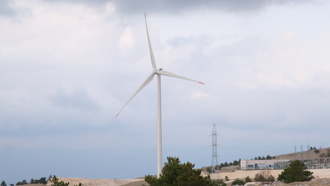A large wind turbine plant. Sustainable and renewable green energy from the wind. Turbines arranged on a mountain plateau. Windy weather before the storm.