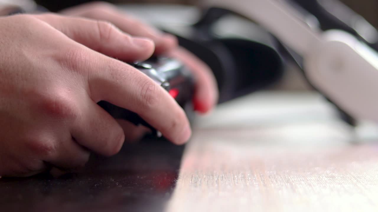 A close up of male hands holding a video game controller playing video games
