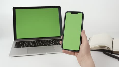 woman using green screen phone. green screen mock up on smartphone and laptop