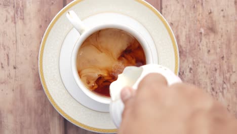 pouring milk into tea