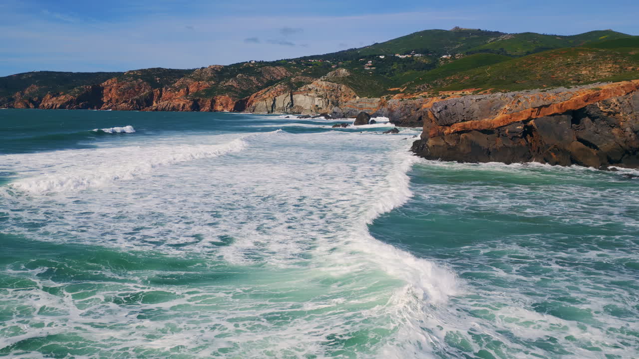 vista aérea de las olas marinas que golpean la costa rocosa con espuma blanca en cámara lenta