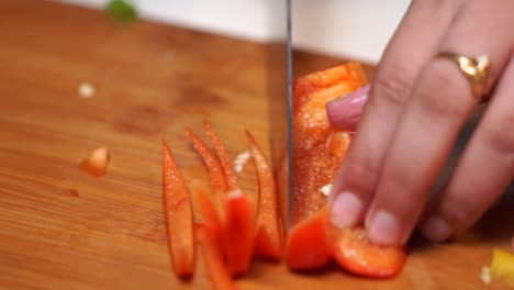 chopping red capsicum on chopping board