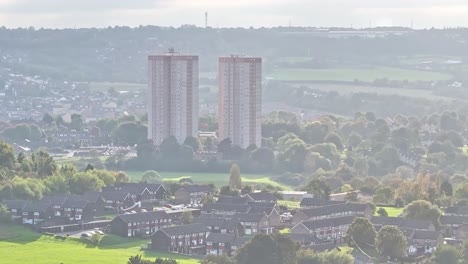 Disparo-Ascendente-De-Un-Dron-Que-Muestra-Dos-Torres-De-Bloques-De-Apartamentos-Rodeadas-De-Parque-Y-Barrio-En-Leeds-Durante-El-Día-Nublado