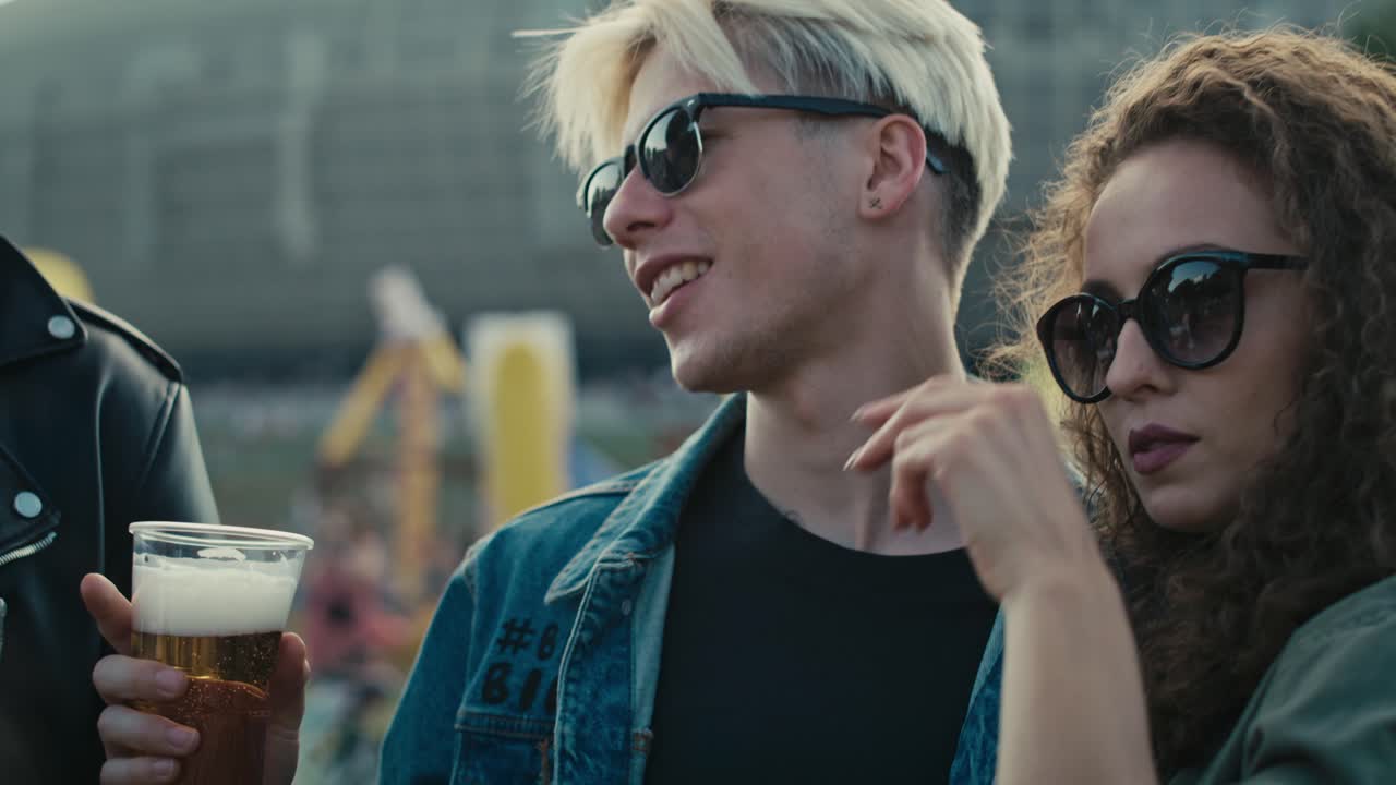 Group of young caucasian friends chatting and  having fun on music festival.