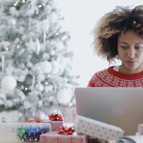 Young-woman-using-a-laptop-at-Christmas