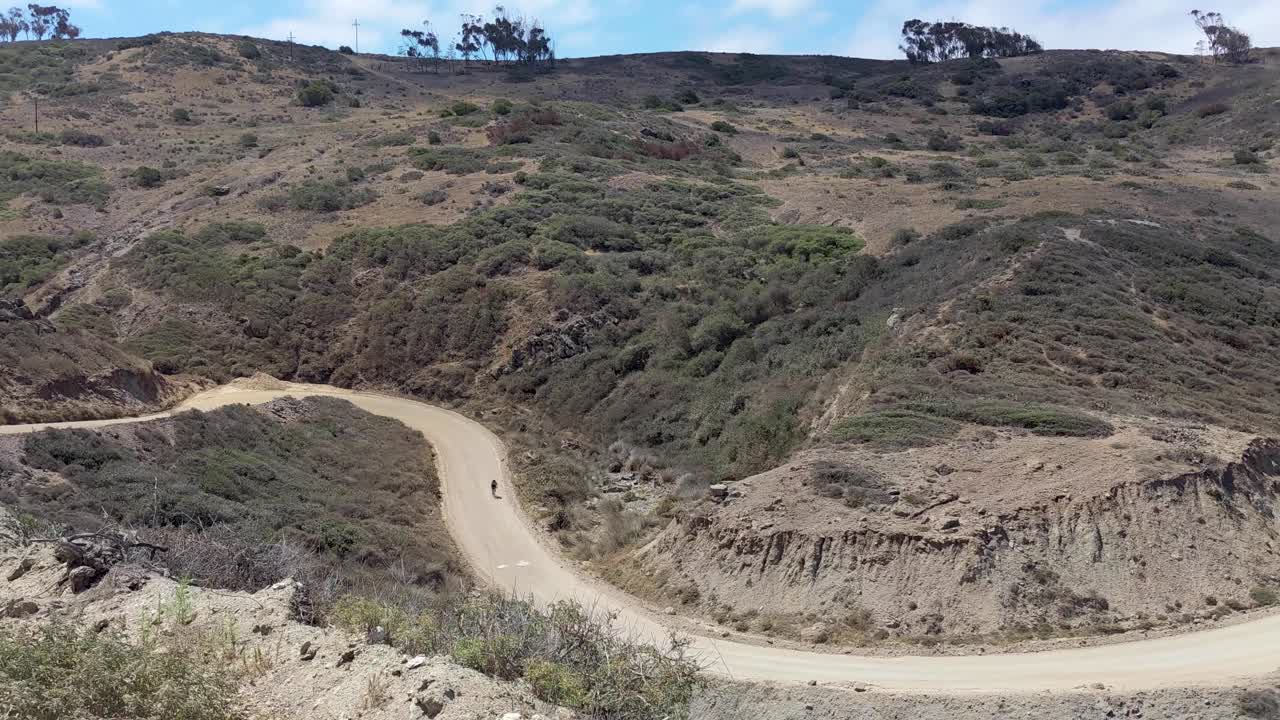 persona montando en bicicleta sola en un camino de tierra en el desierto de la isla catalina de travesía en california