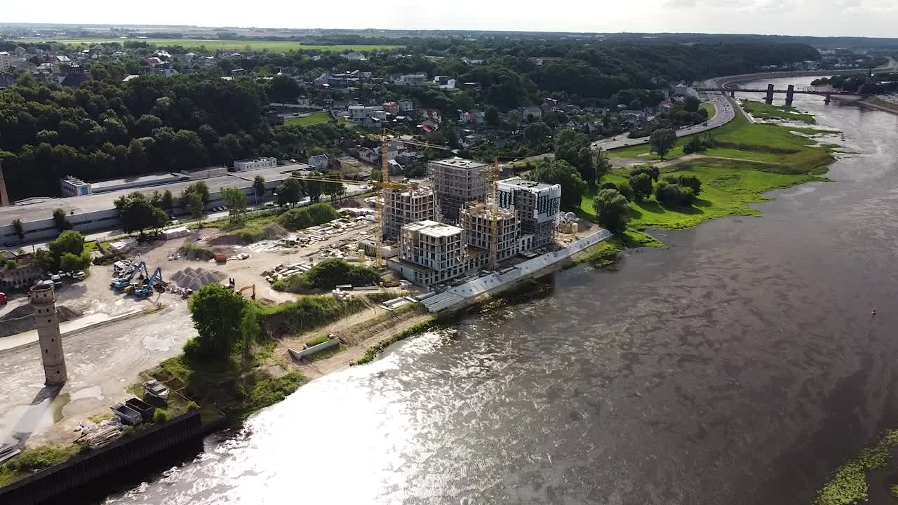 grúas amarillas en el sitio de construcción de nemunaiciai cerca del río nemunas, vista aérea de drones