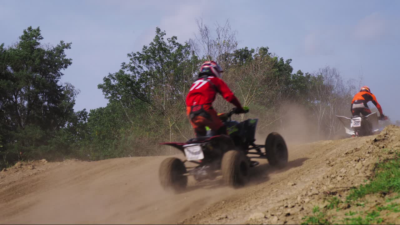 쿼드 바이크 라이더는 토너먼트 중에 언덕을 뛰어 넘습니다.