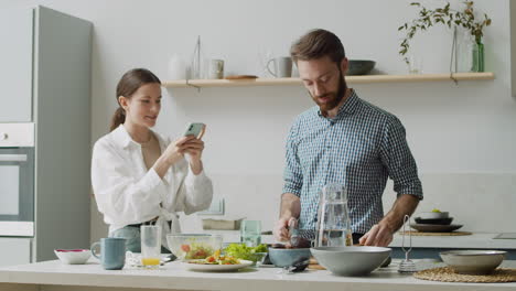 pareja feliz preparando comida en casa