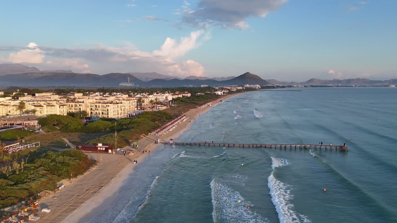 Vista aérea da praia de Playa de Muro e cais de madeira ao pôr do sol, Alcúdia, Maiorca, Espanha