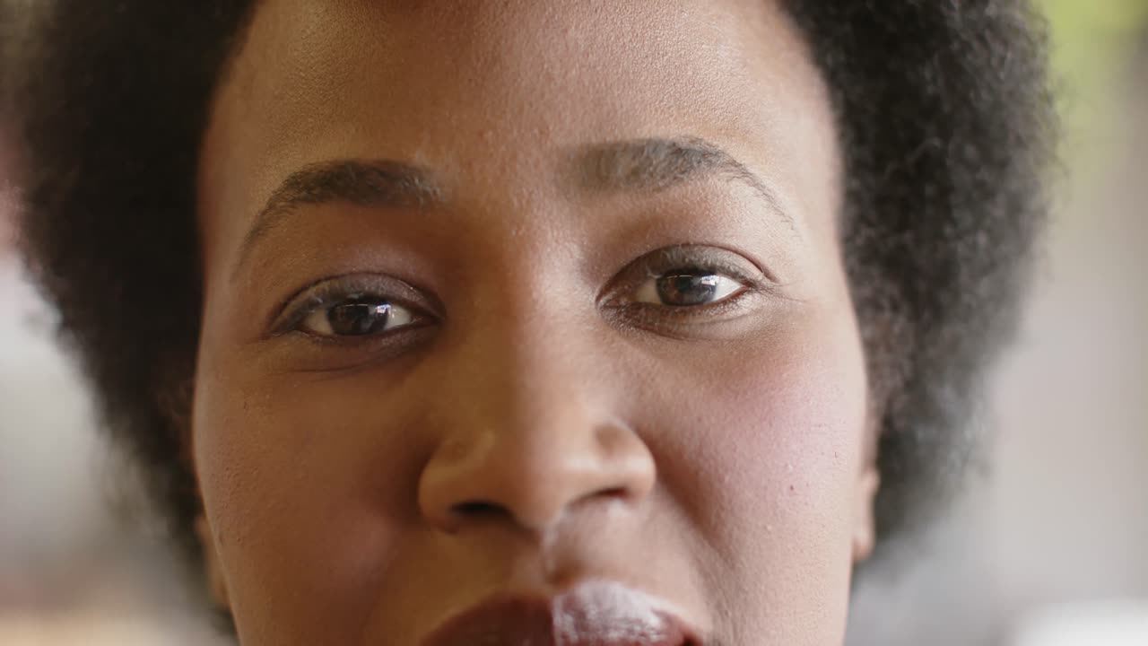 retrato de cerca de una feliz mujer de negocios afroamericana mirando a la cámara y sonriendo, en cámara lenta.