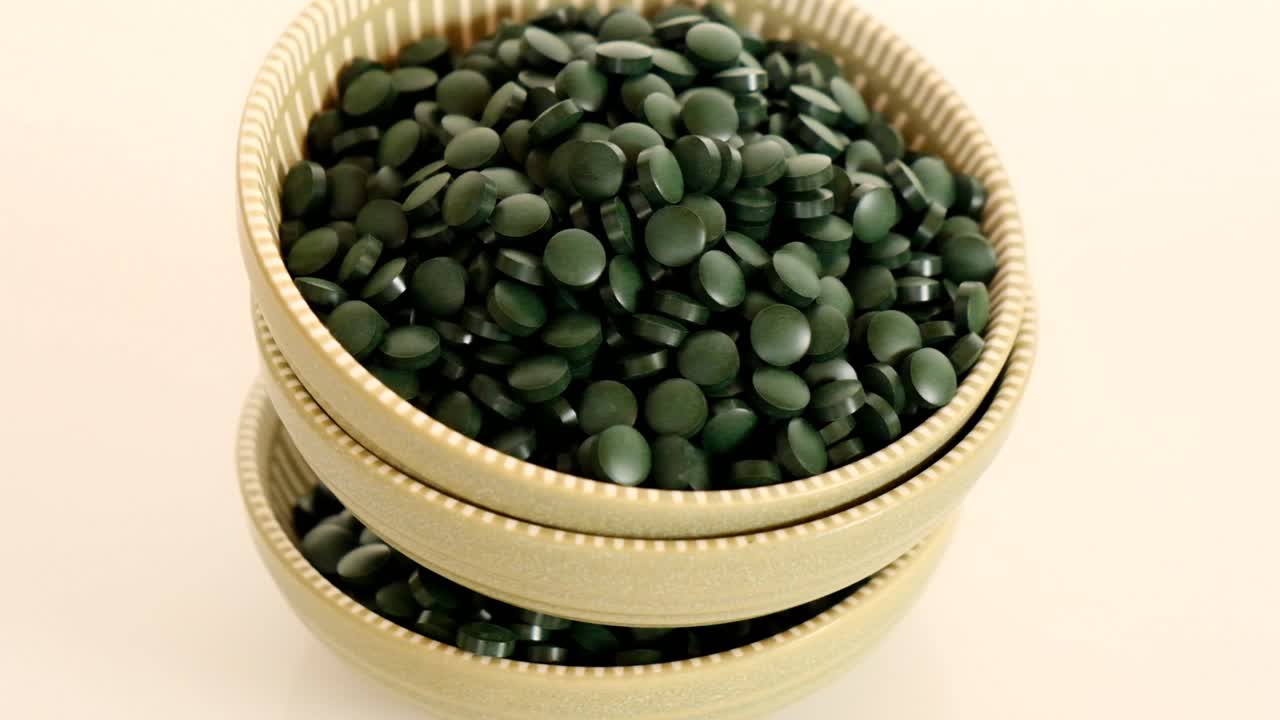 스피루리나 알베스 (spirulina algae green tablets in round green cups) 는 건강한 생활 방식을 위한 식품 보충제입니다.