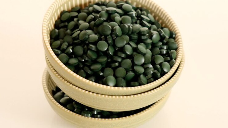 Spirulina pills close-up. Spirulina algae green tablets in round green cups.Super food.seaweed. Food supplements for a healthy lifestyle