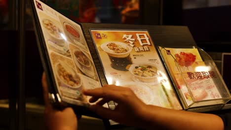 person flipping through a restaurant menu