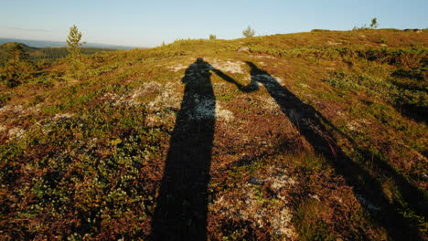 The-Shadows-Of-Two-Travelers-Are-Walking-Along-The-Mountainous-Terrain-Holding-Hands-Active-Lifestyl