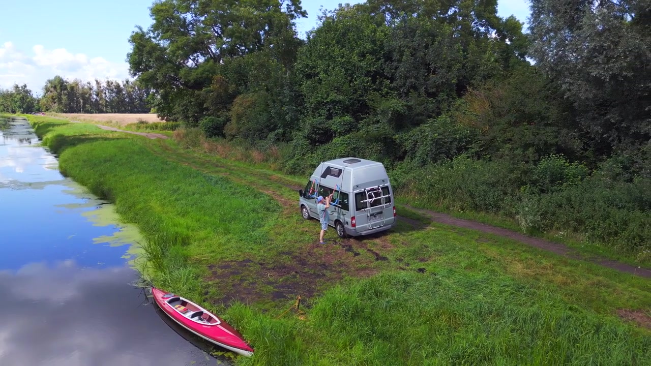 Man red paddle boat shore. Stunning aerial top view flight Caravan Camping Mobile Motorhome at river, summer time Germany 2023 Havelland. panorama orbit drone
4k cinematic
