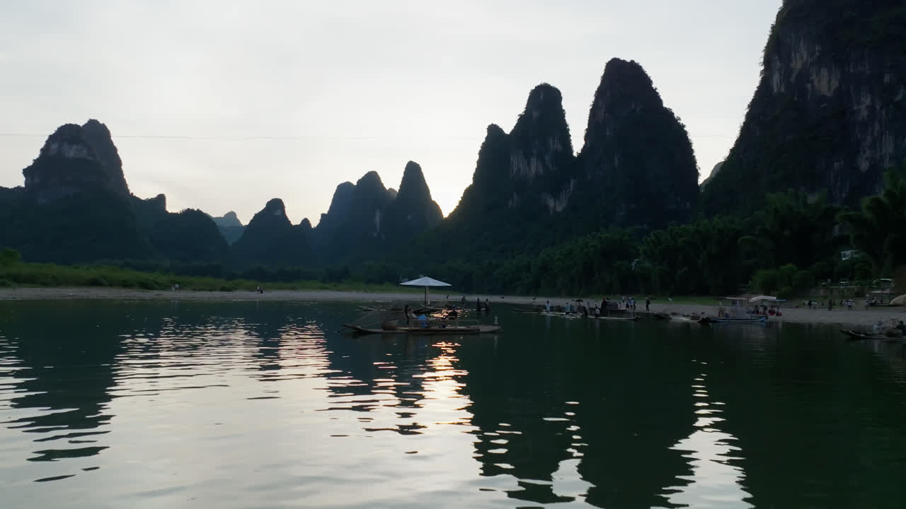 Drone shot of fishermen on wooden rafts, sunny evening in Xingping, China