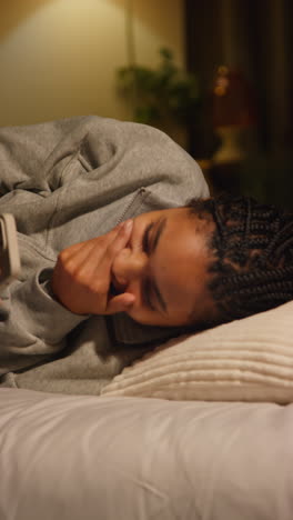 woman lying in bed with phone