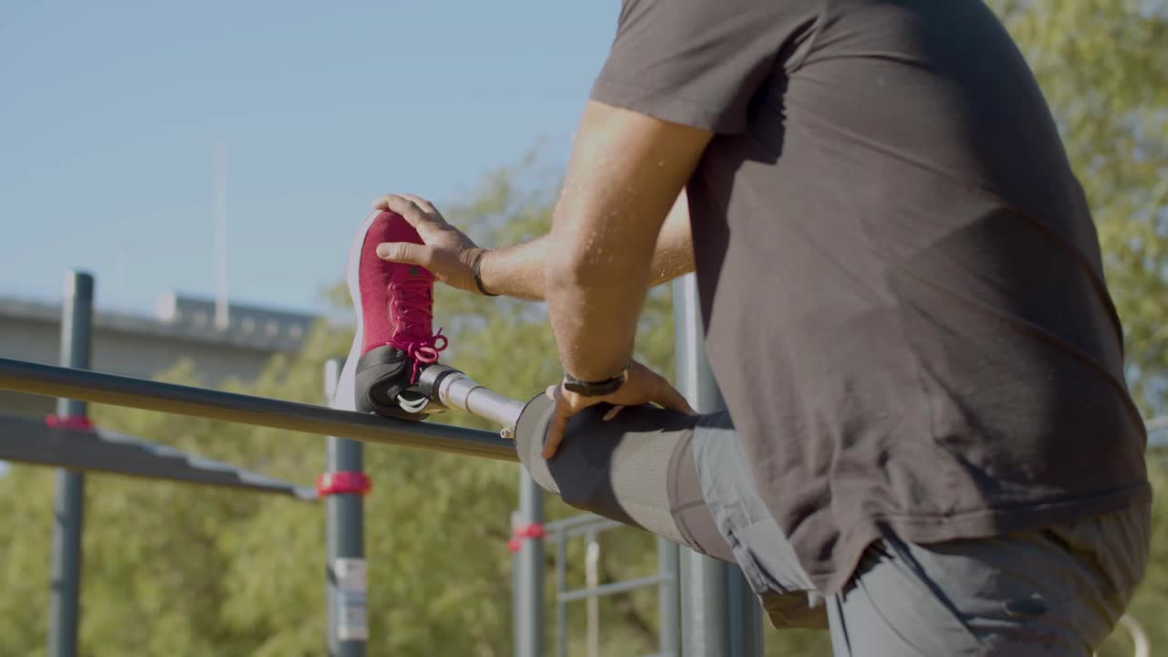 의족을 착용한 남자가 스트레칭 운동을 하는 측면 뷰  ⁇ 입니다.