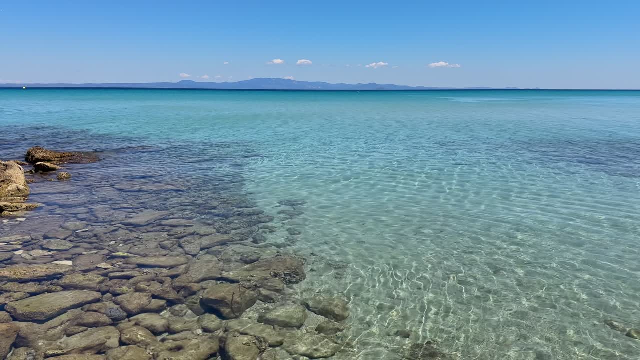 Stunning beach scene in Halkidiki, Greece, with elegant sunbeds facing the crystal-clear turquoise sea. A perfect summer escape in the heart of the Aegean.