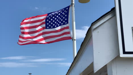 a tattered american flag blows in the breeze in cape cod on a summer day