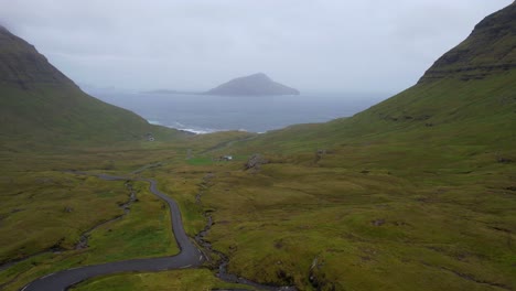 koltur island in fog with driving car passing by a woman revealed, faroe islands